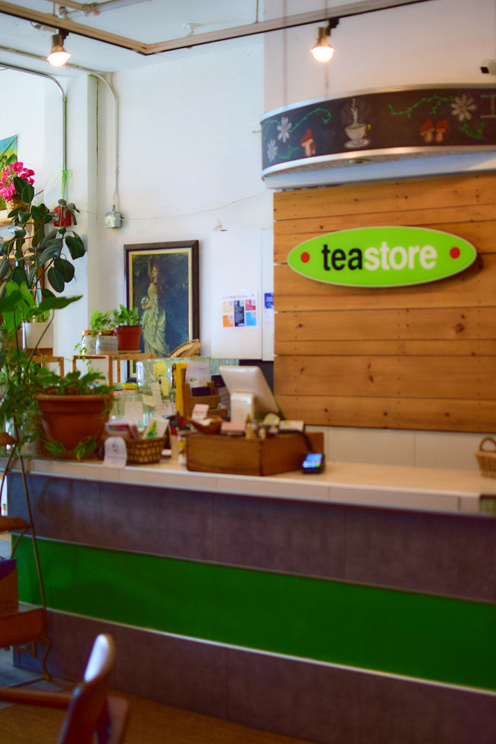 Teastore interior with a counter and 'tea store' sign on the wall.